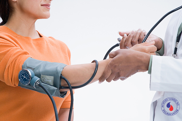 Doctor taking patient's blood pressure